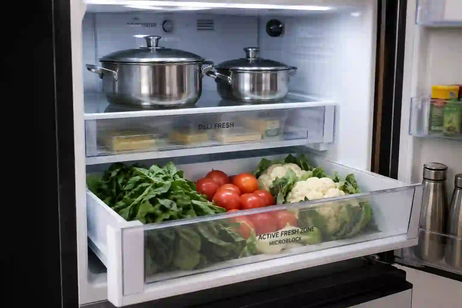 Whirlpool Protton 270L refrigerator interior with fresh vegetables, Active Fresh Zone drawer, and Indian cookware storage